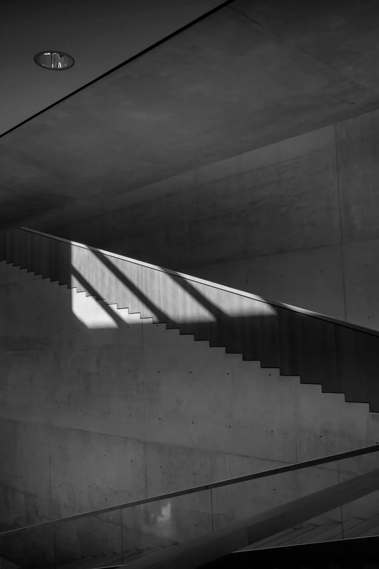 Sunlight tracing the geometry of a concrete staircase.
